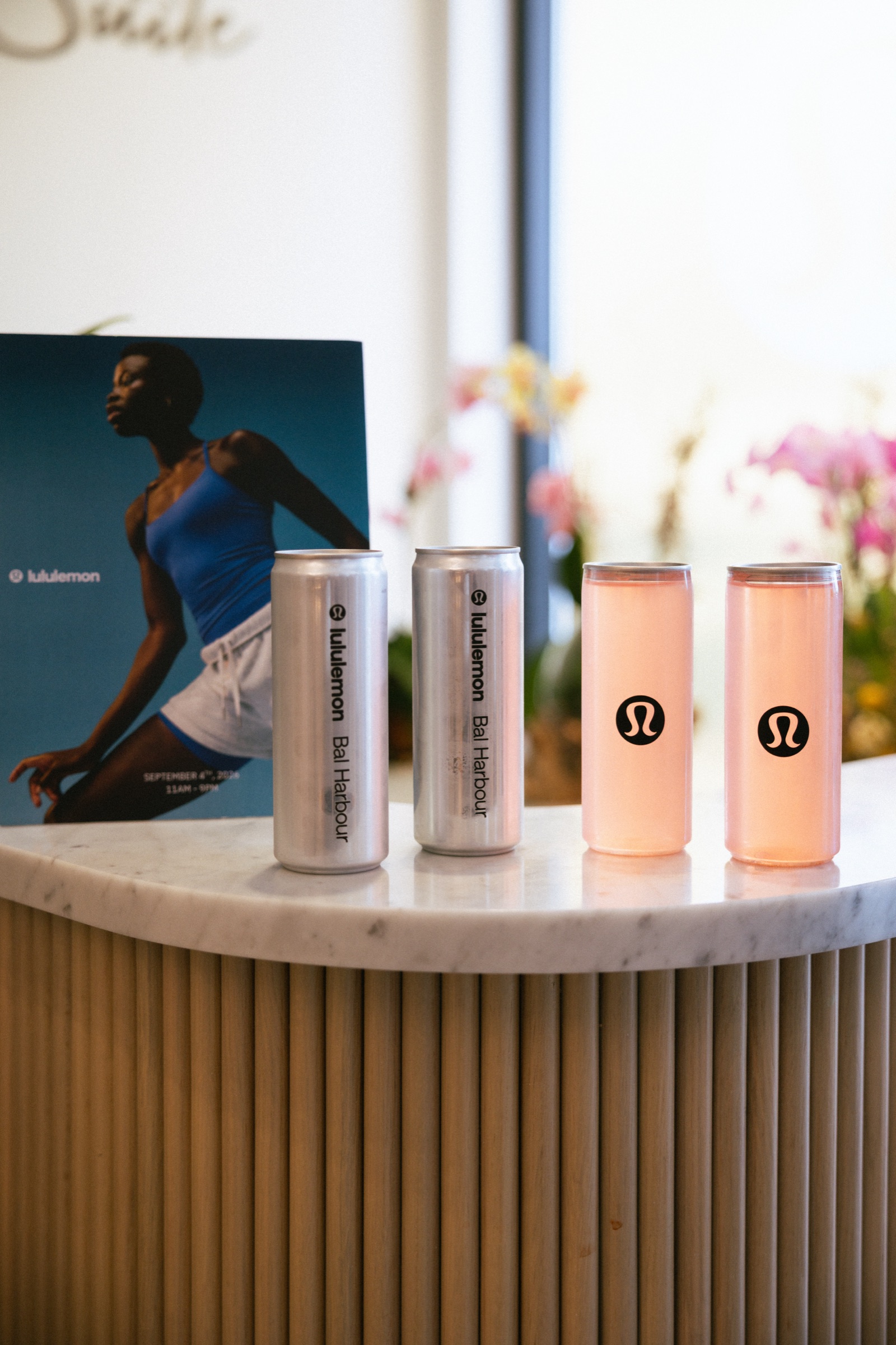 Branded cans and pink watermelon beverages displayed for a Pilates brand activation in Bal Harbour